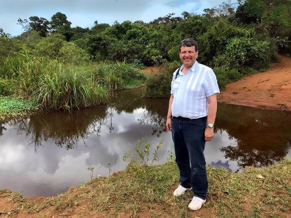 Dr Douglas Wilson is pictured here beside a normal village water source in Tanzania in June 2019.